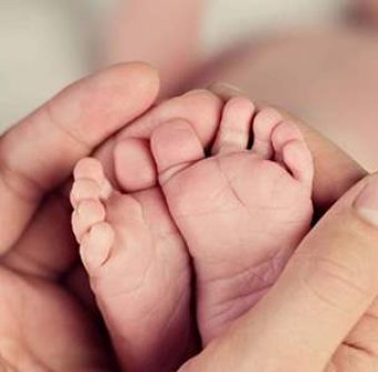 adult-holding-baby-feet